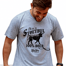 Load image into Gallery viewer, A man wearing a light gray t-shirt with a black and white bull design and the text 'EK IS 'N STOETBUL 100% BOER" printed on it.