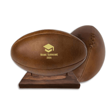 Load image into Gallery viewer, Personalised leather rugby ball with custom branding South Africa handcrafted gift on wooden ball stand.