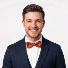 Load image into Gallery viewer, Groom in navy tuxedo wearing rust leather bow tie.
