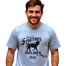 Load image into Gallery viewer, A man wearing a light gray t-shirt with a black and white bull design and the text 'EK IS 'N STOETBUL 100% BOER" printed on it.
