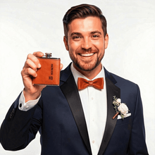 Load image into Gallery viewer, Groom holding personalised leather hip flask with initials, wedding gift.
